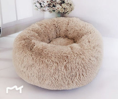 All Dogs Love plush round calming pet bed in beige with a raised rim for head support and cozy long-pile fabric.