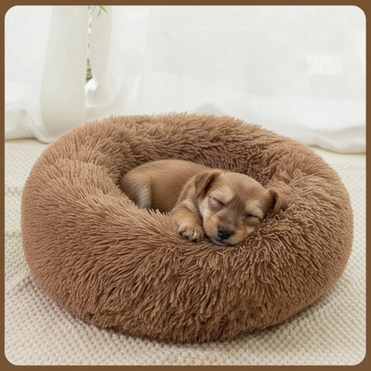 All Dogs Love plush round calming pet bed in brown with a small puppy sleeping inside on a soft textured surface