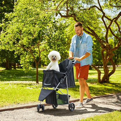 All Dogs Love 3-wheel foldable pet stroller with a white dog in a park, pushed by a man on a sunny day.